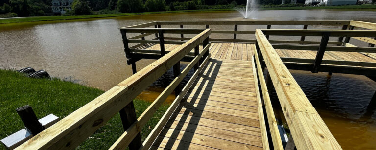 Elevated pond pier with double handrails and a pierhead