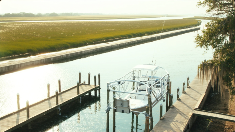 Four-post boat lift holding a center console boat above a Charleston tidal creek