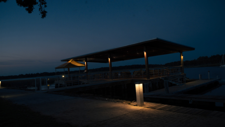 Charleston dock pierhead lit at dusk with low-level deck lighting and a dock power pedestal