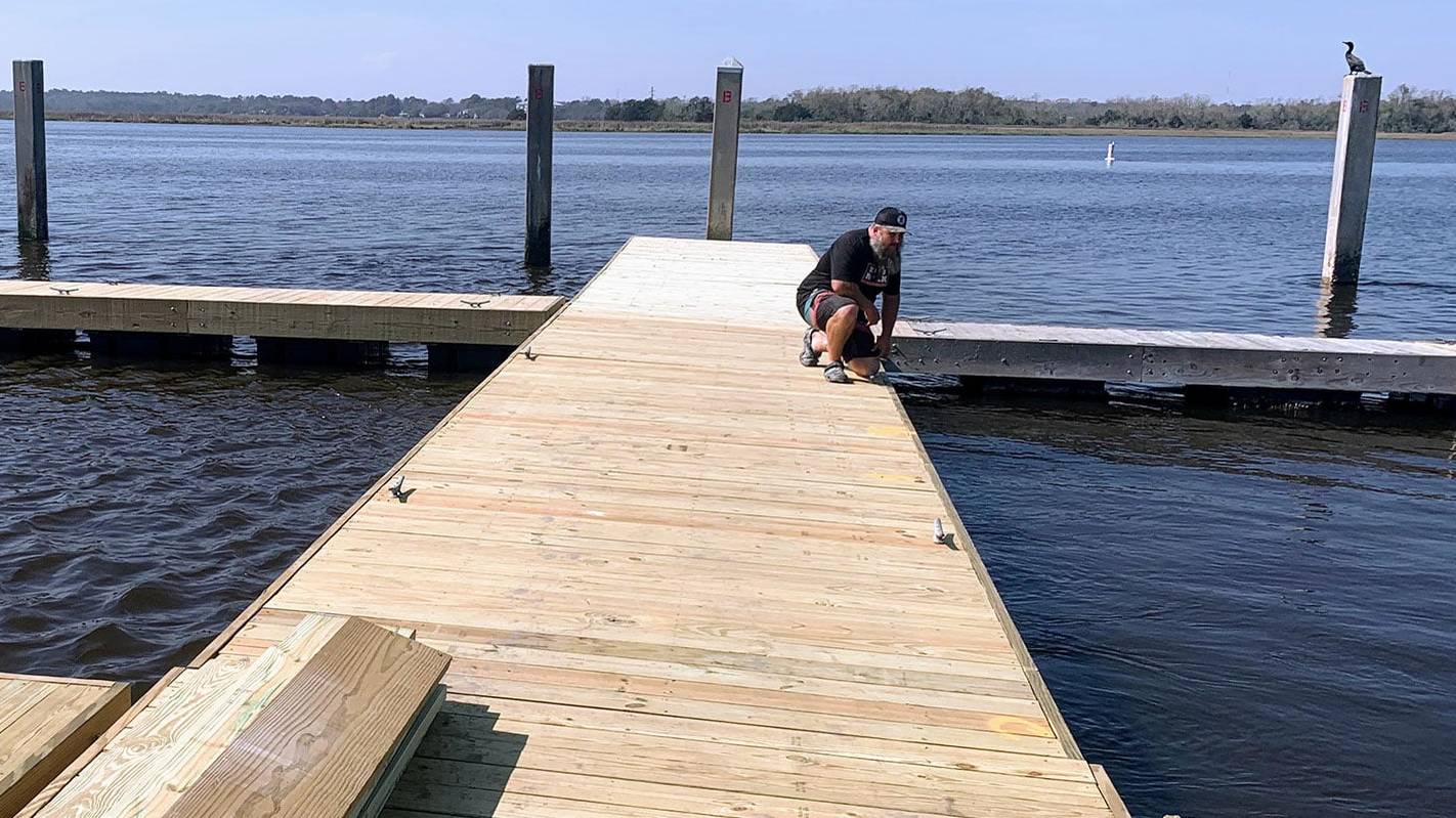 Charleston Dock Doctors crew member finishing a new floating dock on a Charleston river